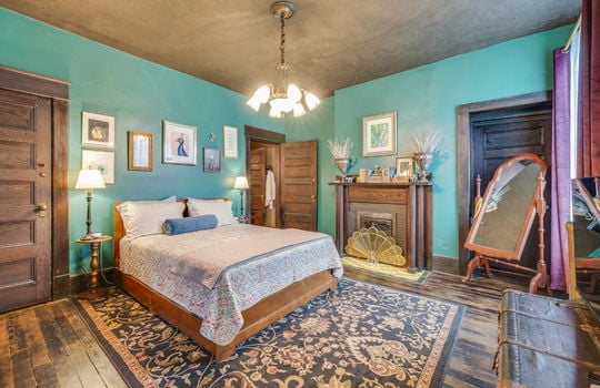 bedroom, closet, wood doors, wood trim, wood mantle, hardwood flooring, windows, chandelier