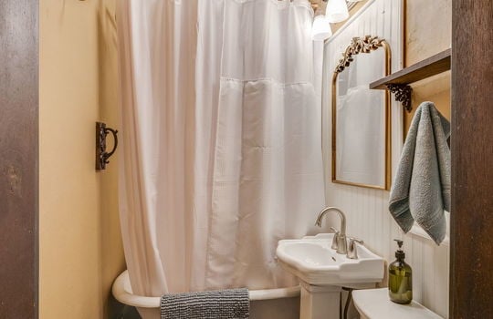 bathroom, hardwood flooring, claw foot tub with shower, toilet, sink