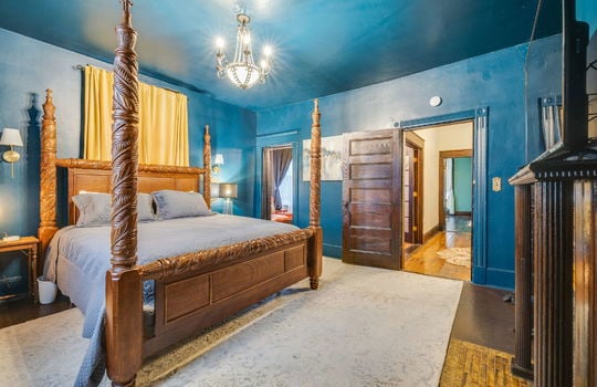 bedroom, hardwood flooring, chandelier, fireplace, wood mantle