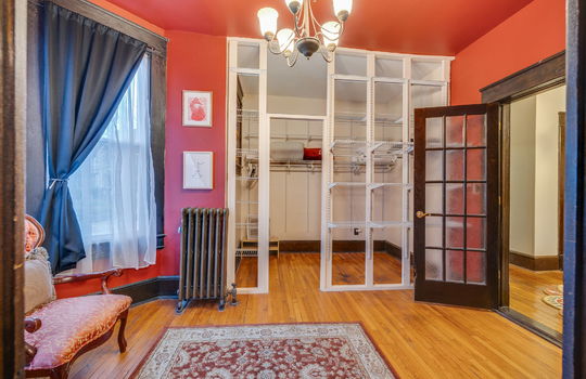 walk in closet with sitting area and shelving, radiator, wood french doors, hardwood flooring, bay windows