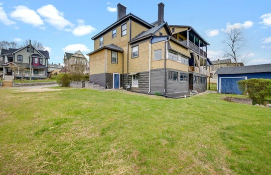 back view of home, storage shed, yard, wood siding, victorian home, nearby homes