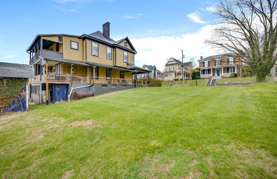 back view of home, storage shed, yard, wood siding, victorian home, nearby homes
