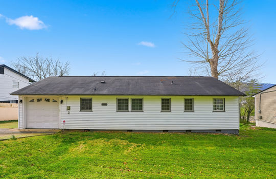 one level ranch home, vinyl siding, garage door, windows, roof, yard, driveway, neighboring homes, mountain views