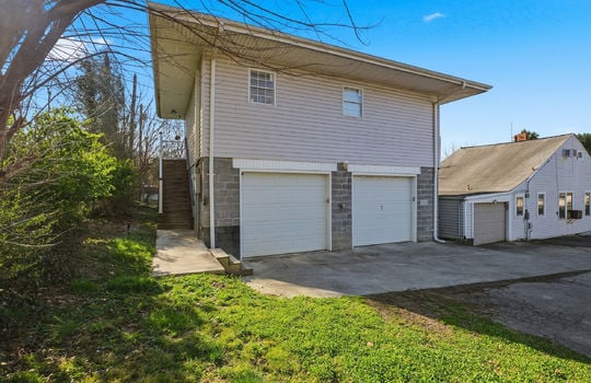 Apartment with 2 car garage drive under garage, vinyl siding, stairs, driveway