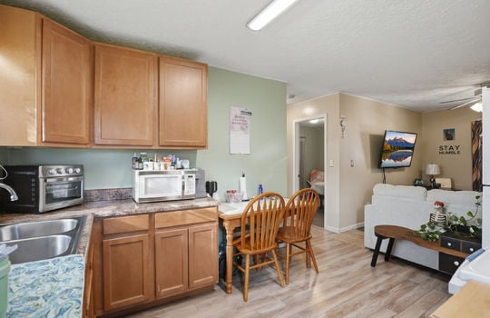 kitchen, laminate flooring, cabinets, countertops, sink, view into living room
