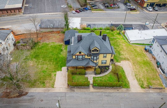overhead Aerial view of home, victorian home, street, front yard, hedge, gravel driveways, sidewalk, nearby homes, shed