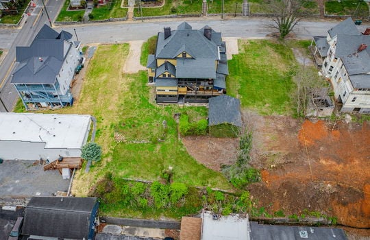 overhead Aerial view of home, victorian home, street, front yard, hedge, gravel driveways, sidewalk, nearby homes, shed