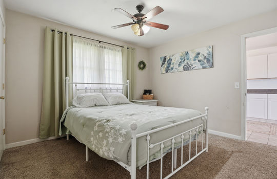 bedroom, carpet, window, ceiling fan, view into kitchen, closet