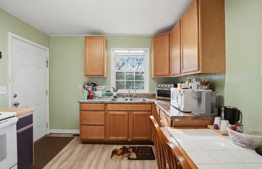 kitchen, exterior door, cabinets, countertops, sink, range, window above sink