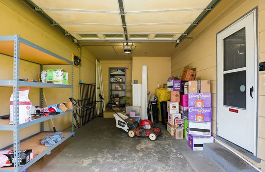 garage, storage shelves, interior entry door, garage door, concrete floor