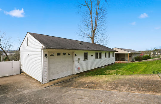 One level ranch style home, concrete driveway, garage, garage door, vinyl siding, windows, fence, gate, yard