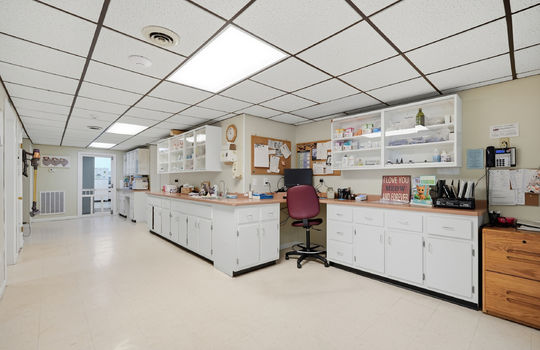 inner office area, storage cabinets, workstations, tile flooring, doors to exam rooms, ceiling tiles, fluorescent lighting