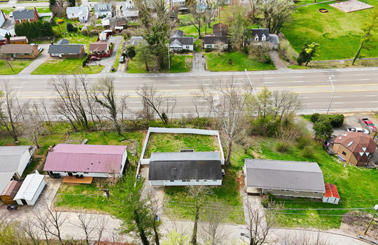 overhead aerial view of home, front yard, back yard, fenced back yard, driveway, garage, road, highway, roof, neighboring homes