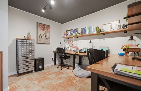 private office space, desk, shelving, concrete flooring, track lighting