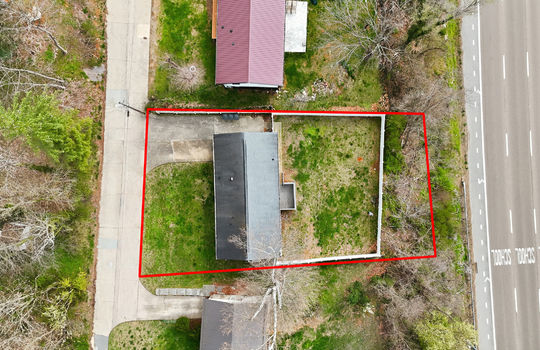 overhead aerial view of home, property outline, neighboring homes, front yard, back yard, roof, back deck, fencing, road, highway