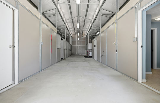 barn interior, stalls, concrete flooring, fluorescent lighting