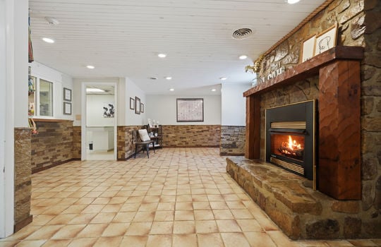 reception area fireplace, stone fireplace, tile flooring, stone wall design, recessed lighting