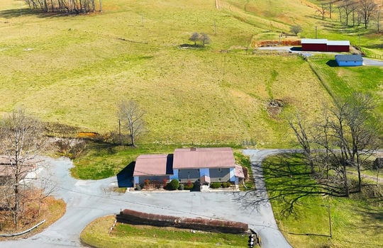 aerial view of veterinary office and land, mountain views, surrounding properties, parking lot, barn
