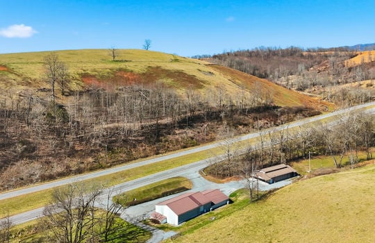 aerial view of veterinary office and land, mountain views, surrounding properties, parking lot, barn