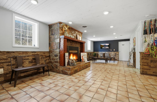 reception/waiting area, stone fireplace, tile flooring, windows, recessed lighting, stone wall design