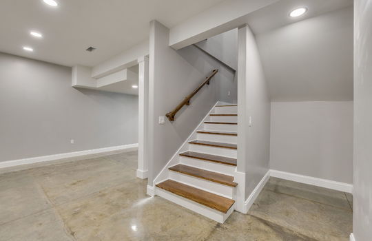 finished basement, stairs to main level, concrete flooring, recessed lighting