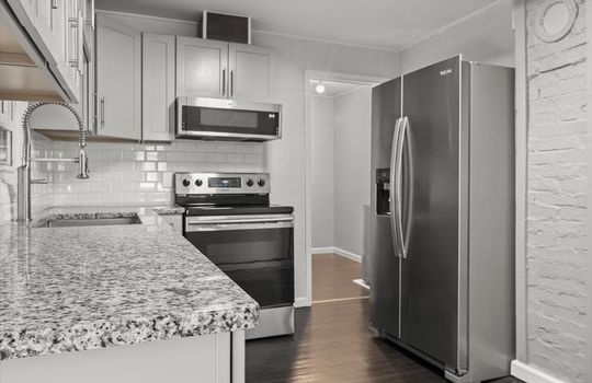 kitchen, granite countertops, sink, built-in microwave, refrigerator, range, tile backsplash, cabinets