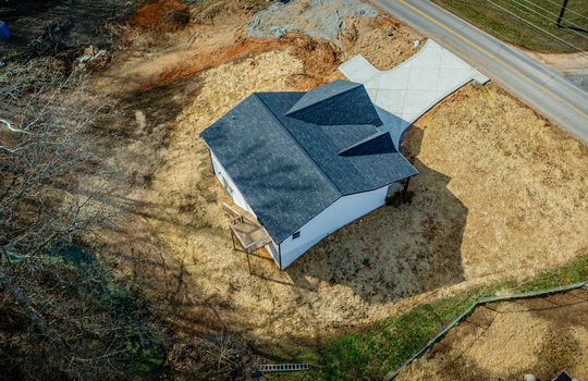 aerial view of home, roaad, driveway, roof, front yard, back yard, creek, back deck