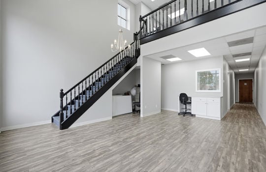 entrance view inward, luxury vinyl flooring, hallway to offices, reception area, stairs to upper level, restrooms