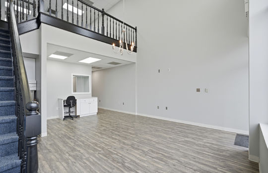 entryway view from stairs, reception area, luxury vinyl flooring, upstairs banisters, chandelier