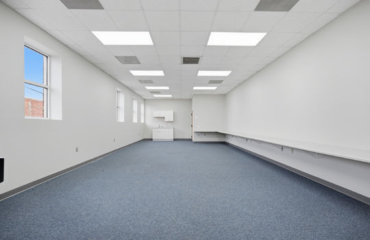 open seating/work area, carpet, built-in desk spaces/shelf, sink, cabinets, windows, ceiling tiles