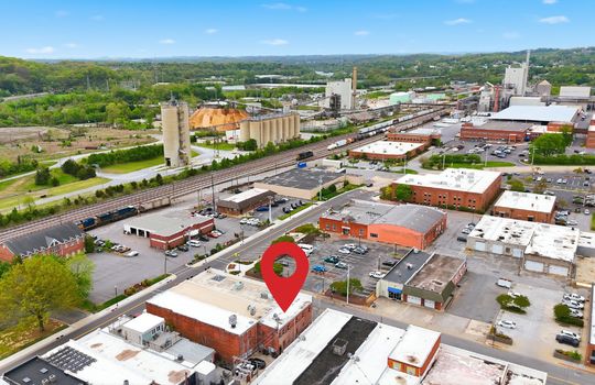 aerial view of commercial space for lease, location pin, main street, road, nearby businesses, mountain views,railroad, brick exterior, street parking, location pin