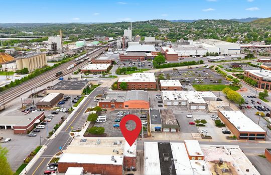 aerial view of commercial space for lease, location pin, main street, road, nearby businesses, mountain views,railroad, brick exterior, street parking, location pin