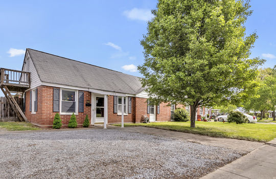 duplex unit for sale, gravel driveway, sidewalk, brick exterior, balcony, front door, covered front entrance