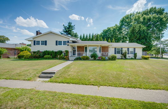 Tri-level home, front yard, sidewalk, covered front porch, vinyl siding, brick, front door, landscaping