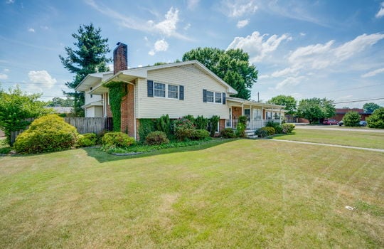 left side view of home, front yard, landscaping, brick, vinyl siding, tri-level home, front porch, covered front porch, fencing