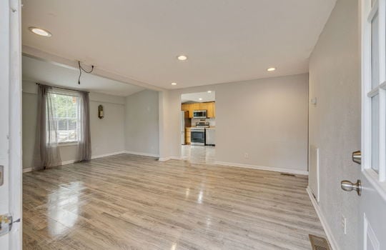 living room, laminate flooring, recessed lighting, doorway to kitchen, window