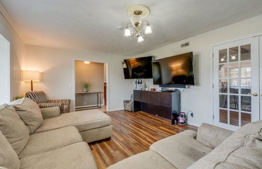 living room, hardwood flooring, doorway to entry hallway, french doors to other room
