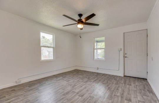 living room, front door, windows, laminate flooring, ceiling fan
