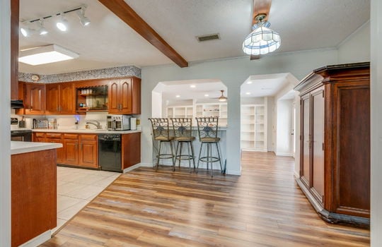kitchen bar seating, hardwood flooring, tile flooring, sink, cabinets
