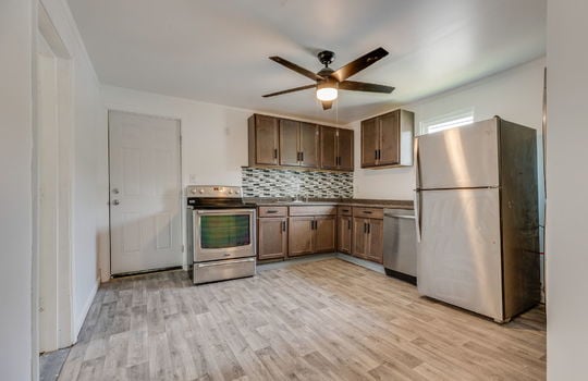 kitchen, stainless steel appliances, refrigerator, dishwasher, range, countertops, cabinets, sink, laminate flooring, ceiling fan