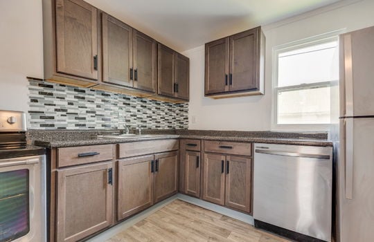 kitchen, cabinets, countertops, stainless appliances, sink, range, dishwasher, refrigerator, window, tile backsplash, laminate flooring