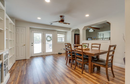 dining area, hardwood flooring, built-in shelving, doorway to kitchen, ceiling fan, double doors to outside