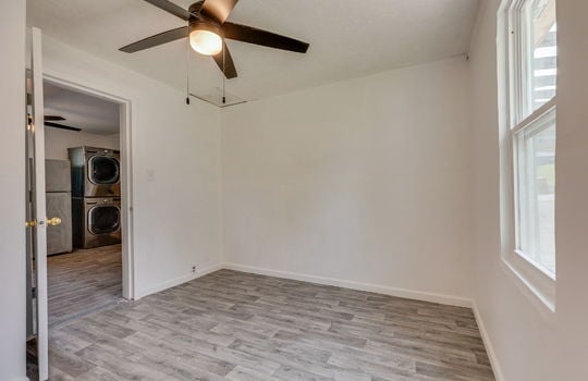 bedroom, window, ceiling fan, laminate flooring, doorway into kitchen