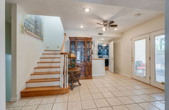 stairs to upper level, doorway to bedroom, built-in shelving, multi-purpose area, doors to outside