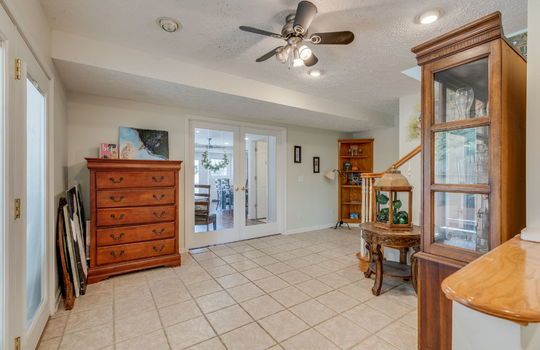 multi-purpose area, tile flooring, ceiling fan, doors to outside, stairs to upper level