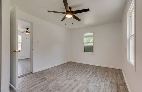 living room, laminate flooring, ceiling fan, windows, doorway to living room