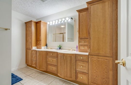 primary bathroom, built-in double sink, custom cabinetry, tile flooring