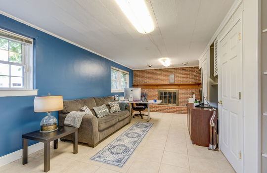 den, tile flooring, brick fireplace, windows