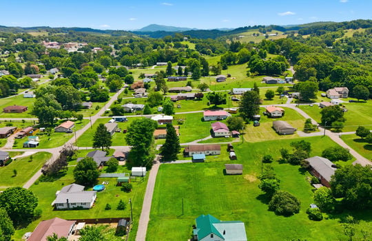 Aerial photo, land, 0.331+/- acres, neighboring homes, road, trees, mountains
