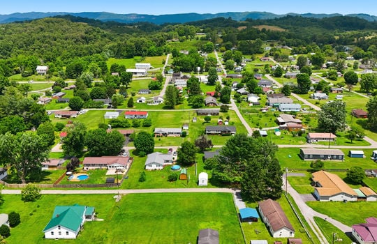 Aerial photo, land, 0.331+/- acres, neighboring homes, road, trees, mountains
